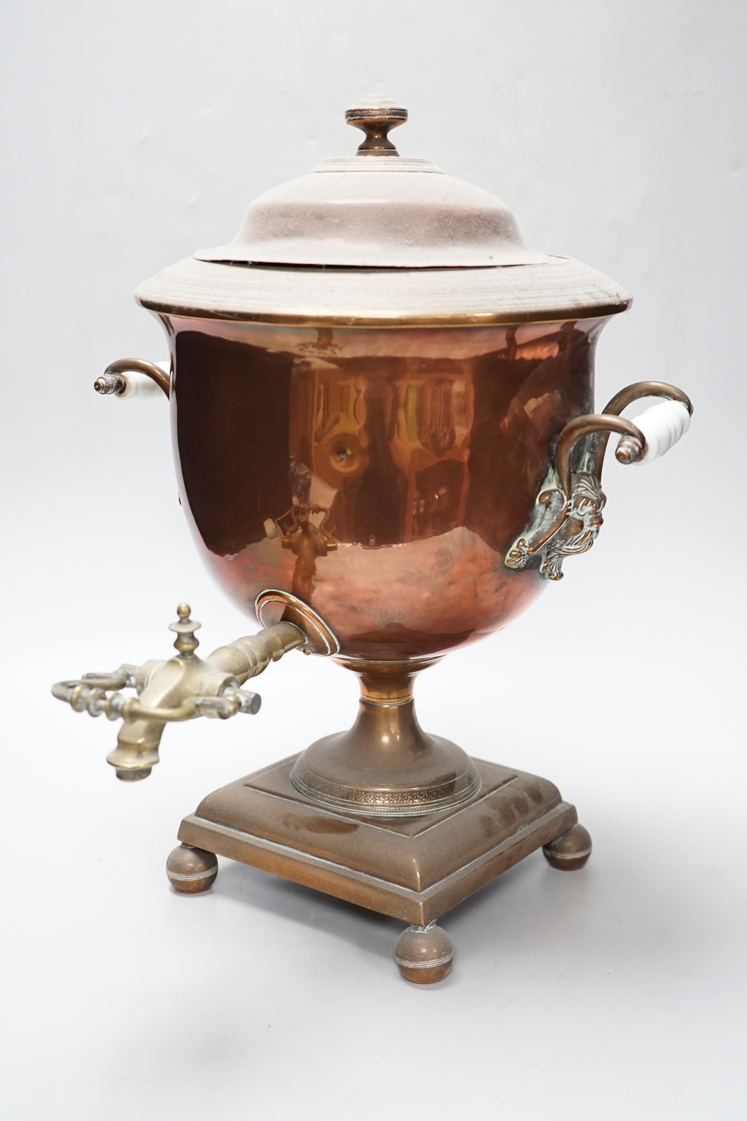 A copper tea urn with brass spigot tap and handles, 44cm